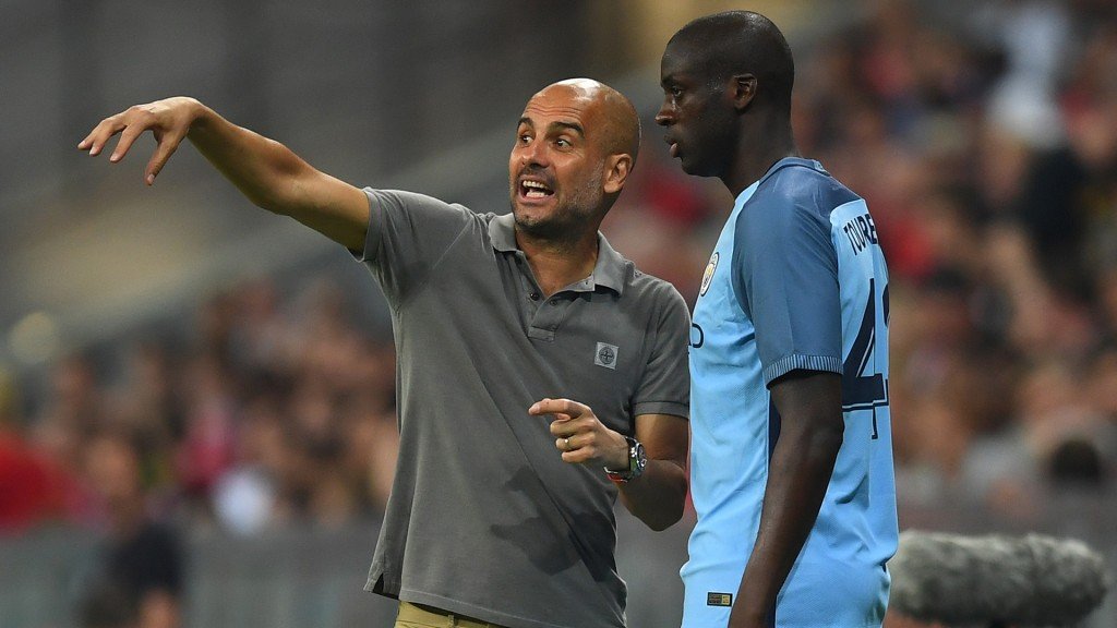 MUNICH, GERMANY - JULY 20: Pep Guardiola the manager of Manchester City speaks with substitute Yaya Toure of Manchester City during the pre season friendly match between Bayern Muenchen and Manchester City F.C at the Allianz Arena on July 20, 2016 in Munich, Germany. (Photo by Lennart Preiss/Bongarts/Getty Images)