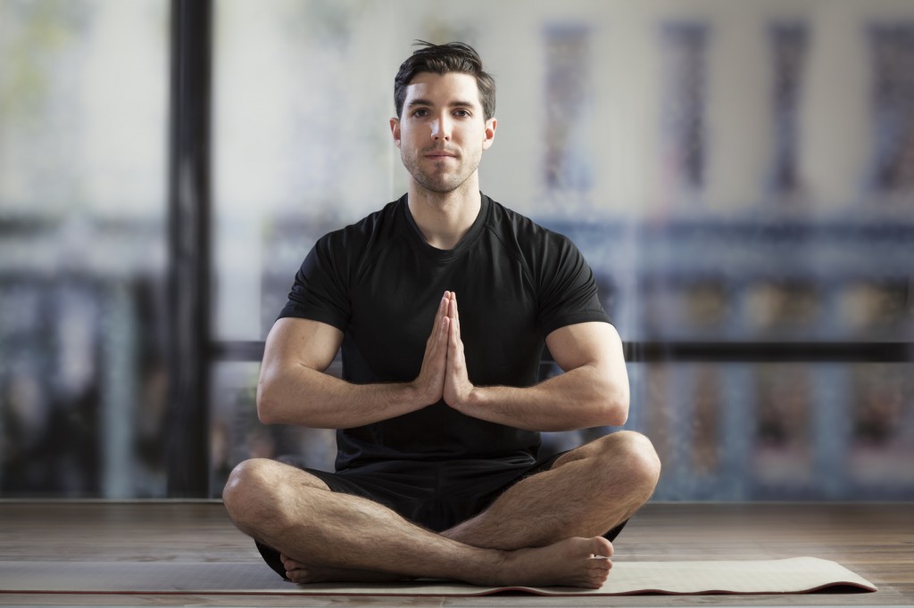 young man doing yoga in office